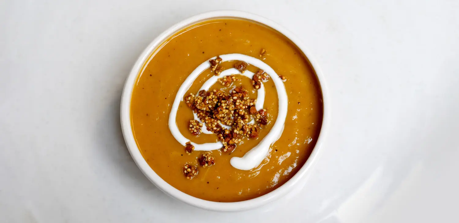 Bowl of Roasted Butternut Squash and Pear Soup with Pistachio-Millet Crunch