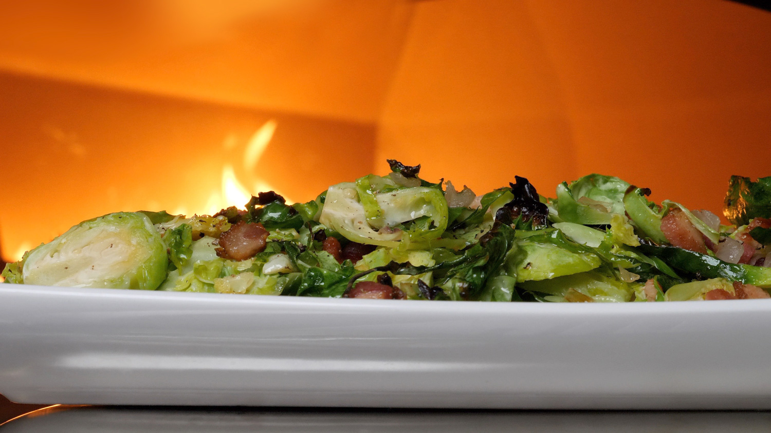 Brussels Sprouts dish with flame in the background