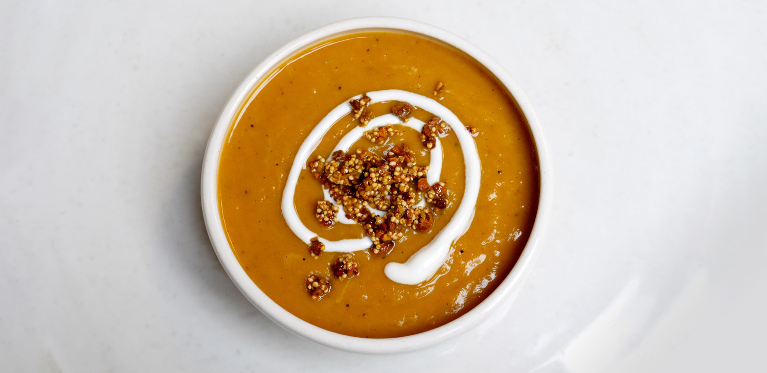 Bowl of Roasted Butternut Squash and Pear Soup with Pistachio-Millet Crunch